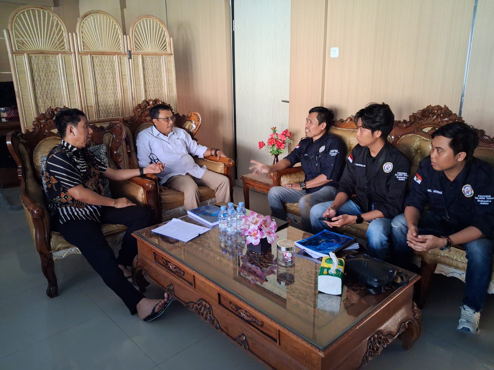 Sekelompok peserta duduk berhadapan dalam pertemuan di sebuah ruangan